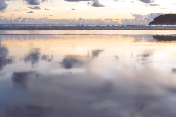 Sea wave and beach sand with refection of sky on sunset time. Nobody nature calm and relax background - Foto, afbeelding