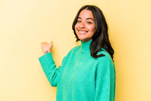 Young hispanic woman isolated on yellow background showing a welcome expression. - Valokuva, kuva