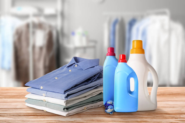 Montón de ropa y detergentes en la mesa de la tintorería - Foto, Imagen