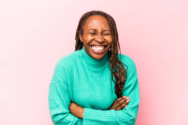 Young african american woman isolated on pink background laughing and having fun. - Fotó, kép