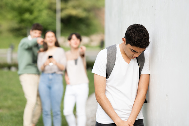 Triste adolescente hispano contra la pared sufriendo bullying. - Foto, Imagen