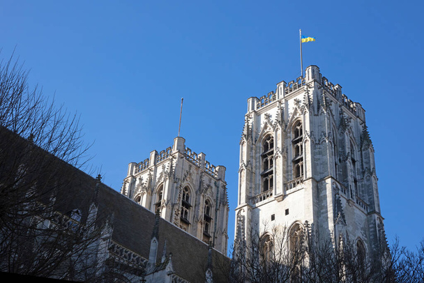 Brussels, Belgium on februari 25, 2022 - Ukrainian flag waving at the St. Michael and St. Gudula Cathedral in Brussels, Belgium. - Фото, зображення