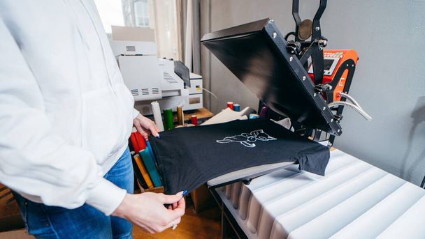 Desktop thermo press for printing images on black t-shirt at fabric . - Fotó, kép