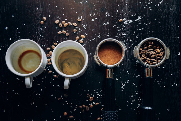 Белая чашка горячего вкусного кофе стоит на столе с кофейными зёрнами - Фото, изображение