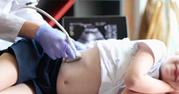 Lekarz prowadzący badanie ultrasonograficzne nerek do dziecka w klinice zbliżenie 4k film - Materiał filmowy, wideo