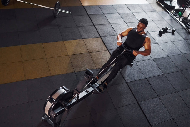 Homem americano africano forte em roupas esportivas tem dia de treino no ginásio e usando equipamentos. Concepção de poder e força. - Foto, Imagem