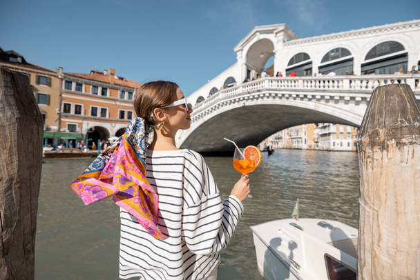 Женщина наслаждается летним напитком во время путешествия по Венеции - Фото, изображение
