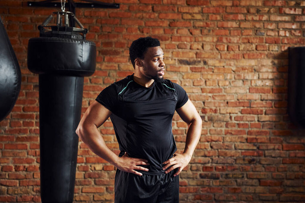 Homme afro-américain fort en vêtements de sport debout dans la salle de gym. - Photo, image