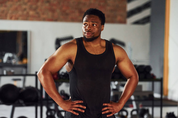 Strong african american man in sportive clothes standing in the gym. - 写真・画像