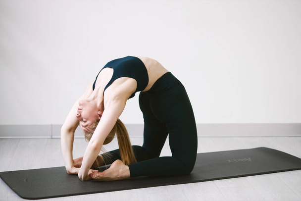 Atletica bella ragazza che fa yoga e stretching in quarantena - Foto, immagini