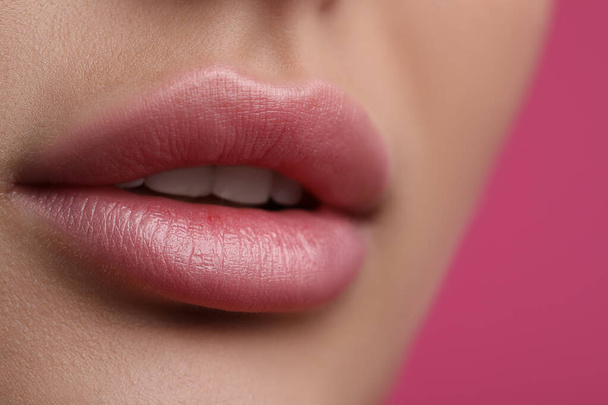 Mujer joven con hermosos labios sobre fondo rosa, vista de cerca - Foto, Imagen