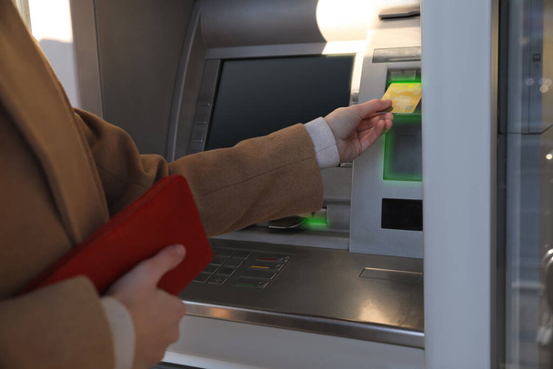 Young woman using cash machine for money withdrawal outdoors, closeup - Foto, Imagen