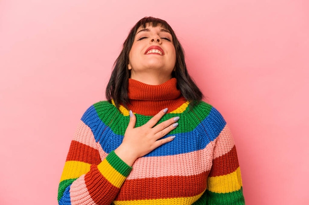 Young caucasian woman isolated on pink background laughs out loudly keeping hand on chest. - Photo, Image