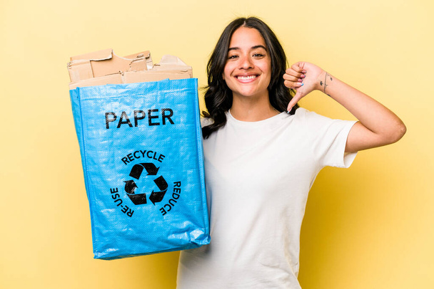 Jovem mulher hispânica reciclagem de papel isolado em fundo amarelo se sente orgulhoso e auto-confiante, exemplo a seguir. - Foto, Imagem