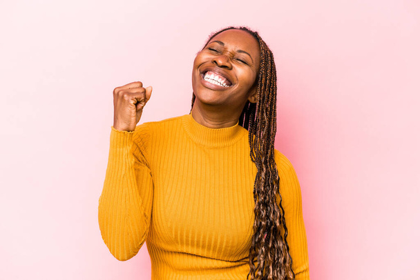 Young african american woman isolated on pink background celebrating a victory, passion and enthusiasm, happy expression. - 写真・画像
