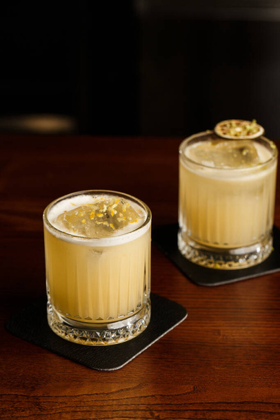 Des cocktails chauds. Cocktail Mezcal et alcool Scotch Whiskey Penicillin Drink Cocktail. Cocktail verre sur comptoir bar. - Photo, image