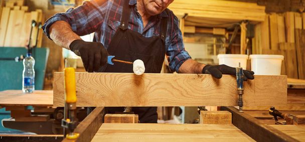 Ritratto di falegname anziano in barre di legno uniformi incollate con pressione manuale nella fabbricazione di falegnameria - Foto, immagini