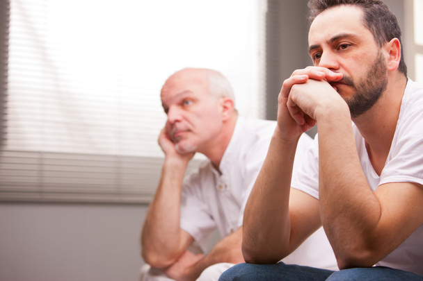hombres preocupados por algo en una sala de estar
 - Foto, Imagen
