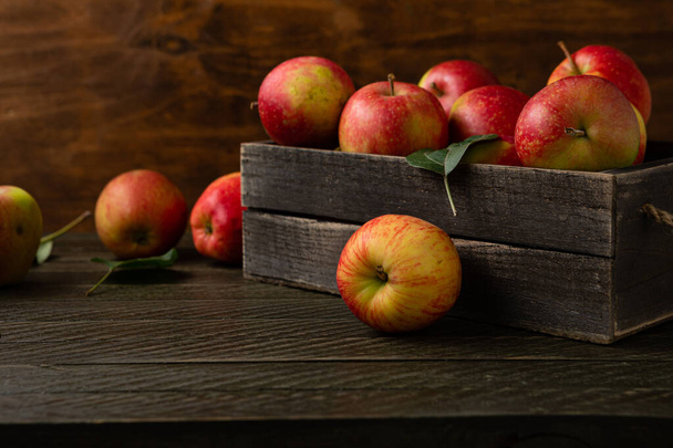 Close up Fresh harvest of apples in a wooden box food dark background  - Photo, image