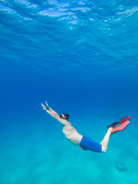 man underwater in scuba mask diving under water copy space - 写真・画像