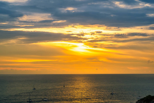 Słońce zachodzi w czasie zachodu słońca w Promthep Cape w Phuket, Tajlandia. - Zdjęcie, obraz