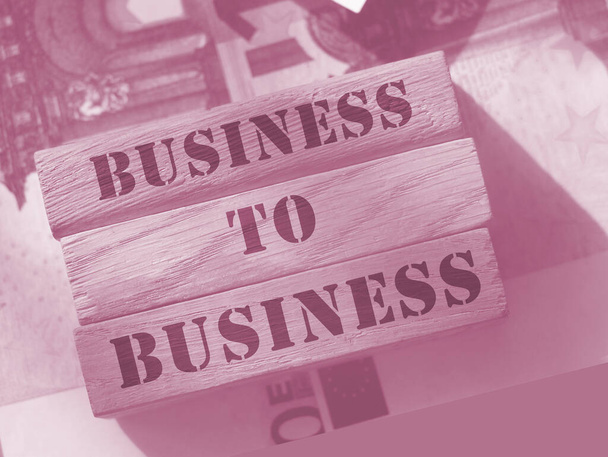 Business to business sur des blocs en bois mis sur des billets de 100 euros. Concept de marketing B2B. - Photo, image