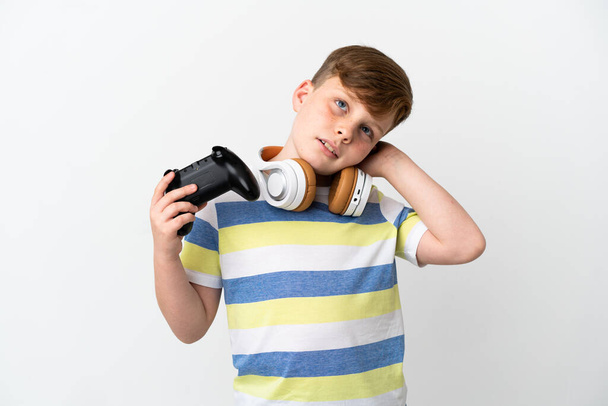 Маленький рудий хлопчик тримає ігровий майданчик ізольований на білому тлі, маючи сумніви
 - Фото, зображення