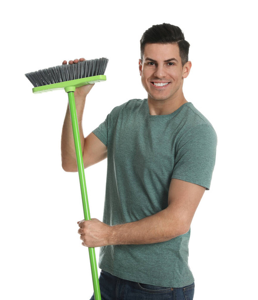 Man with green broom on white background - Фото, изображение
