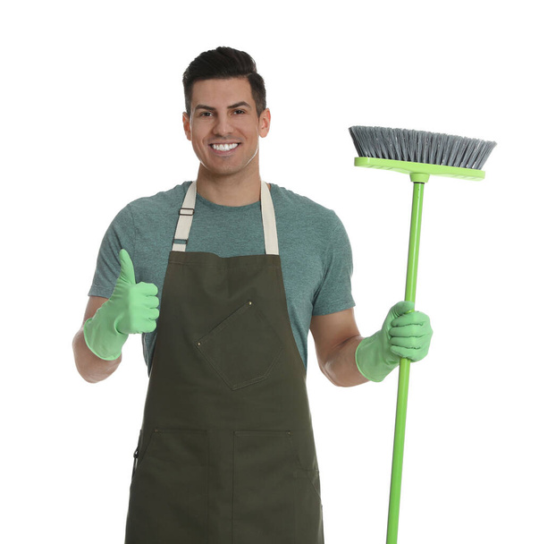 Man with green broom on white background - Foto, imagen
