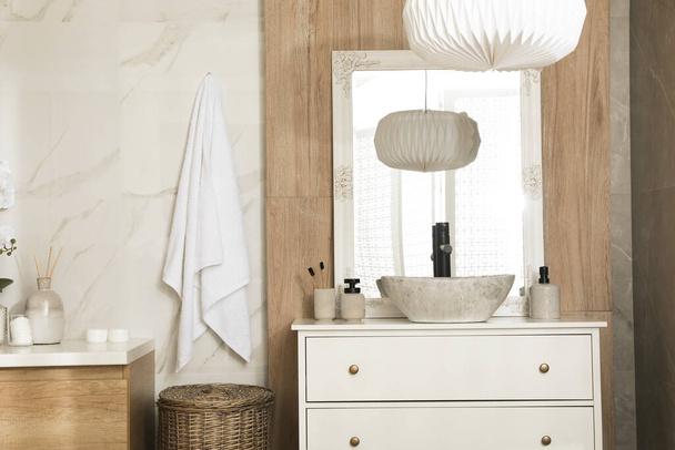 Chest of drawers with sink, mirror and toiletries in bathroom. Interior design - Valokuva, kuva