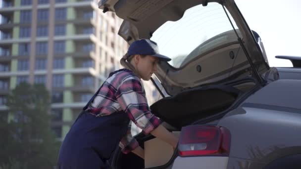Courrier de livraison de femme prenant des boîtes du coffre de voiture - Séquence, vidéo