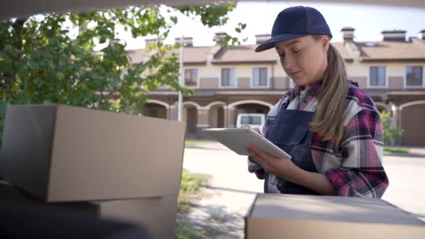 Delivery woman checking orders on tablet outdoors - Footage, Video