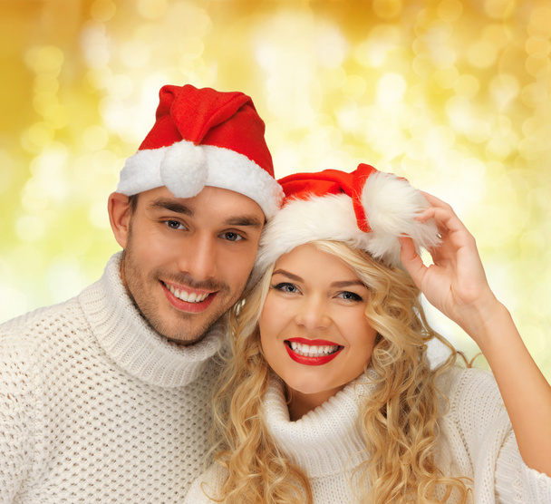 smiling couple in sweaters and santa helper hats - Foto, Imagen