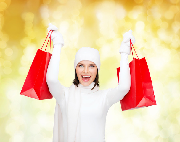 smiling young woman with red shopping bags - Фото, зображення