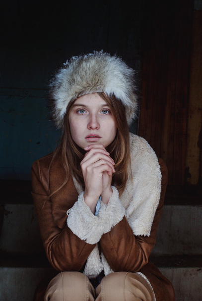 Portrait photo of winter cold girl sitting on steps - 写真・画像