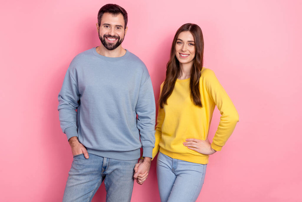 Portrait of two cheerful lovely people hold arms toothy smile isolated on pink color background - Фото, изображение