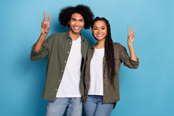 Photo of positive spouses lady guy make v-sign wear stylish trendy shirt jeans isolated on blue color background - Zdjęcie, obraz