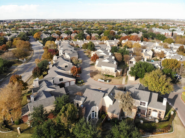 Top view twee verdiepingen herenhuizen omgeven door kleurrijke herfst gebladerte in de buitenwijken van Dallas, Texas, Amerika. Woonwijk met aangrenzende herenhuizen en kleine achtertuin - Foto, afbeelding