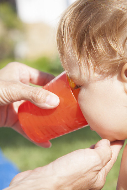 baby drinking orange cup - Photo, Image