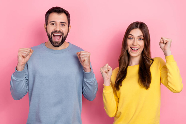 Photo of two delighted astonished partners raise fists celebrate achievement isolated on pink color background - Valokuva, kuva