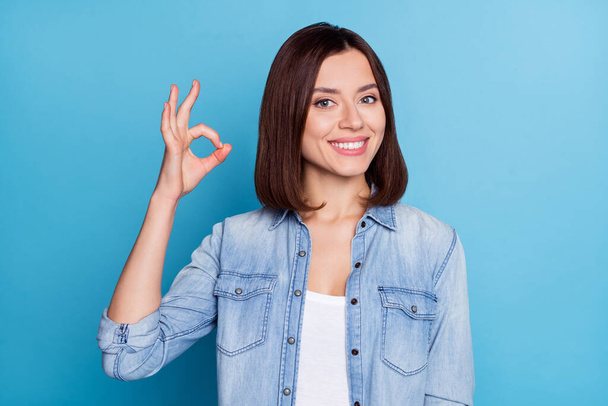 Photo of shiny cute woman wear jeans shirt showing okey sign smiling isolated blue color background - Φωτογραφία, εικόνα