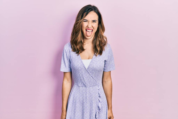 Jong Latijns-Amerikaans meisje met casual kleding die tong uitsteekt blij met grappige uitdrukking. emotie concept.  - Foto, afbeelding