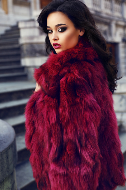 beautiful girl with dark hair wearing  fashion red fur coat - 写真・画像