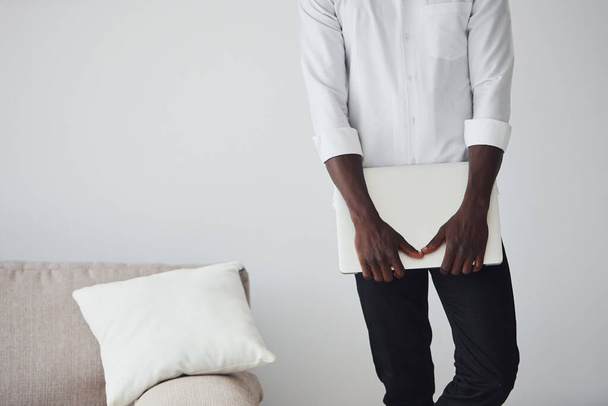 Young african american man in formal clothes indoors with laptop in hands. - Photo, Image