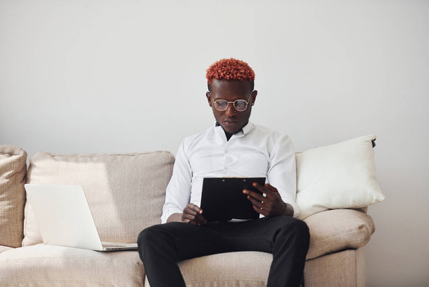 Young african american man in formal clothes indoors with laptop in hands. - Foto, Imagen