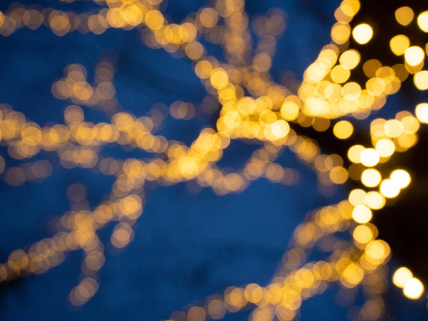 Christmas background with bokeh of a luminous garland on a tree - Foto, Imagem