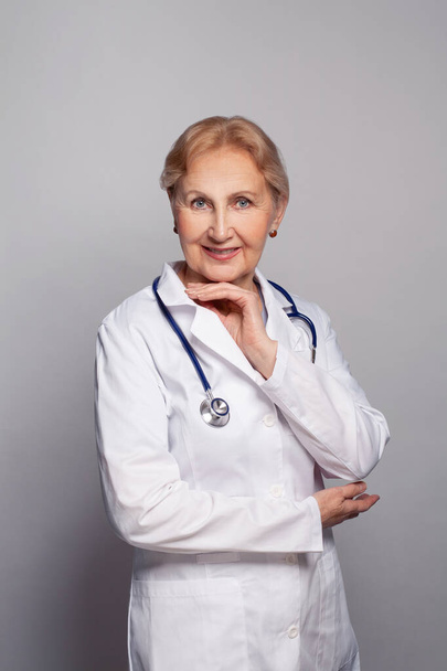 Nainen lääkäri seisoo stetoskooppi kaulassaan ja hymyilee - Valokuva, kuva