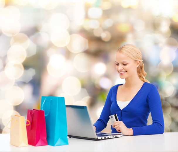 smiling woman with credit card and laptop - 写真・画像