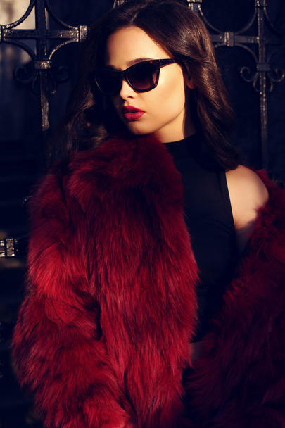 portrait of sexy girl with dark hair in luxurious fur coat and sunglasses - Valokuva, kuva