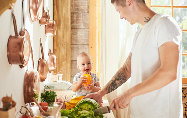 Lasst uns Mama mit einem Mittagessen überraschen. Vater und Sohn kochen in der Küche zu Mittag. Familie, Essen, gesunde Ernährung, Kochen und Menschen-Konzept. - Foto, Bild